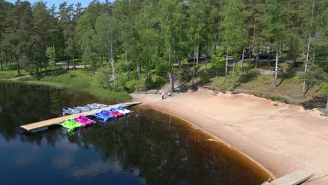 Jet-skis-and-paddle-boats-at-dock-of-alpine-lake-in-Sweden,-aerial