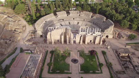 Establishing-aerial-view-Roman-theatre-ruins-of-Merida,-reverse-shot-above-ancient-columns-archaeology