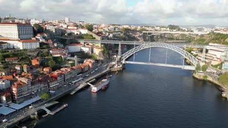 Drohnenschuss-Rückwärts-Fliegend-Mit-Brücke-Im-Blick-In-Porto-Portugal-Bei-Sonnenuntergang