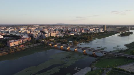 Aerial-view-of-Puente-de-La-Universitad,-A-bridge-over-Guadiana-River-at-sunset,-Badajoz