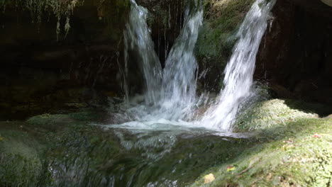 Nahaufnahme-Eines-Kaskadierenden-Wasserfalls,-Der-An-Einem-Sonnigen-Tag-Auf-Einem-Felsigen-Berg-Fließt