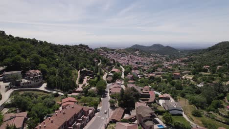 Flyover-of-small-Spanish-village,-nestled-in-mountainous-landscape