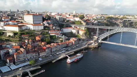 Drone-shot-flying-right-to-left-with-bridge-in-view-in-Porto-Portugal-at-sunset