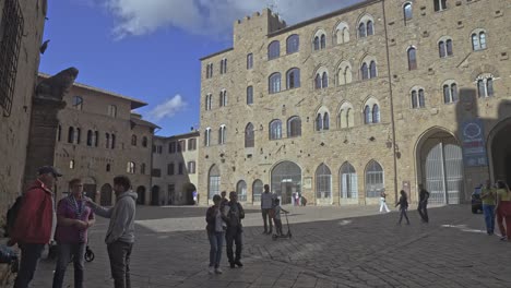 Walking-into-the-Square-of-the-Priors-in-the-walled-town-of-Volterra,-Province-of-Perugia,-Italy