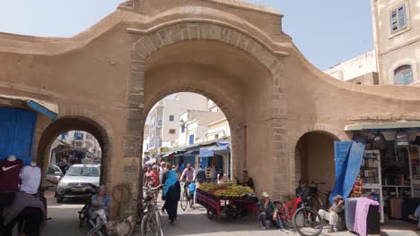 Einheimische-Und-Touristen-Gehen-Durch-Den-Sandsteintorbogen-In-Der-Medina-Von-Essaouira