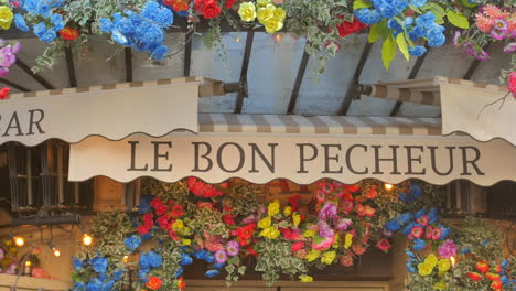 Le-Bon-Pecheur-Restaurant-Sign-with-Colorful-Flowers-In-Paris,-France