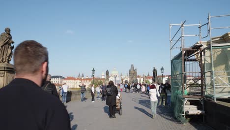 Lebhafte-Atmosphäre-Von-Prag,-Wenn-Touristen-An-Einem-Sonnigen-Tag-über-Die-Berühmte-Karlsbrücke-Schlendern