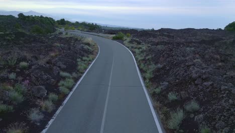Road-surrounded-by-volcanic-landscape-Etna-Sicily,-Damaged-asphalt-strip