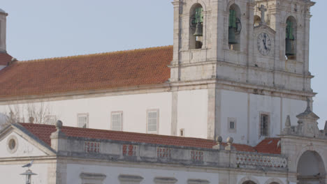 The-church-behind-a-dancing-woman-at-a-candy-stand-in-Nazare,-Portugal