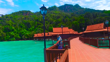 a-relaxed-man-on-a-stilt-of-a-luxury-hotel-looks-out-to-sea-in-langkawi-island