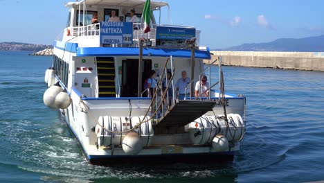 Aufnahme-Eines-Touristischen-Motorbootes,-Das-An-Einem-Sonnigen-Tag-Entlang-Der-Süditalienischen-Insel-Procida,-Coricella,-Kampanien,-Anlegt