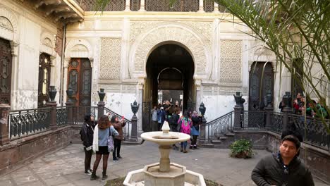 Tiro-De-Mano-Dentro-Del-Palacio-De-La-Alhambra-Arquitectura-Morisca-En-Santiago,-Fuente-De-La-Ciudadela-De-Chile-Hito-Con-Turistas