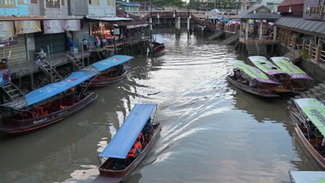 Ein-Langes-Boot-Mit-Blauem-Dach,-Das-Mit-Touristischen-Sehenswürdigkeiten-In-Amphawa,-Samut-Songkhram,-Thailand,-Aufwartet