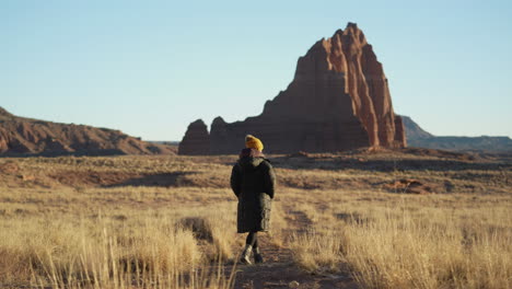 Back-View-of-Woman-in-Warm-Clothes-Walking-on-Path-in-Capitol-Reef-National-Park,-Utah-USA
