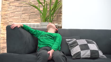 a-child-tired-in-front-of-the-TV-he-falls-asleep-on-the-sofa
