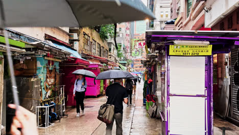 Gente-Con-Paraguas-Mientras-Camina-Por-La-Calle-Tai-Yuen-En-Wan-Chai,-Hong-Kong