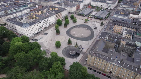 From-an-aerial-perspective,-witness-the-vibrant-city-life-of-Israels-Plads-in-Copenhagen-at-noon,-teeming-with-people-and-activity