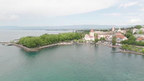 Drone-flying-voer-beautiful-lake-towards-an-old,-medieval-castle-in-Lausanne,-Switzerland