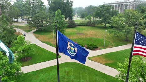 Bandera-Espartana-De-La-Universidad-Estatal-De-Michigan,-Bandera-Del-Estado-De-Michigan-Y-Bandera-Estadounidense-Ondeando-En-El-Campus-De-Msu-En-Un-Día-De-Niebla