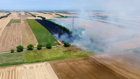 Smoke-Rises-From-A-Burning-Agricultural-Field---aerial-drone-shot