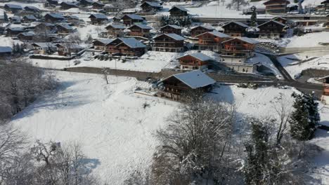 Aerial-of-a-beautiful-chalet-in-a-small-Swiss-town-in-winter