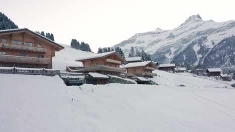 Wide-jib-up-of-multiple-wooden-chalets-in-beautiful-snow-covered-landscape