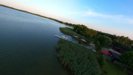 Folgen-Sie-Der-Uferlinie-In-Einer-FPV-Drohne-Bei-Sonnenuntergang-In-Einem-Masurischen-See-In-Polen