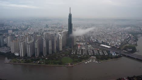 Landmark-skyscraper-with-low-cloud-in-early-morning-aerial-hyperlapse-or-time-lapse-with-warm-sun-hitting-the-buildings-at-the-end-of-clip