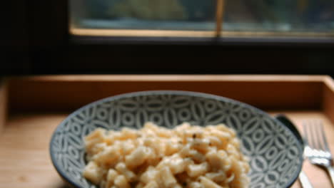 Focus-Pull-Pan-Down-to-Macaroni-Cheese-with-Cutlery