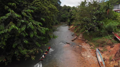 Kampung-Sampan-Bewegt-Sich-Durch-Einen-Ländlichen-Fluss-Neben-Einem-Langhaus