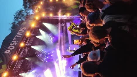 Riga,-Lettland---14.-Juli-2023:-Nicht-Wiederzuerkennende-Fans-Tanzen-Mosh-Pit-Und-Heben-Die-Hände-Bei-Einem-Konzert-Oder-Einer-Festivalparty.-Silhouetten-Eines-Publikums,-Das-Das-Konzert-Vor-Hellen-Bühnenlichtern-Genießt