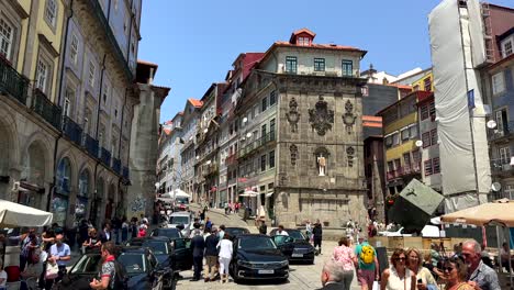 Pov-walk-at-city-center-of-Porto-with-many-pedestrian-and-historic-buildings-build-on-hill-at-sunny-day---Portugal,-Europe