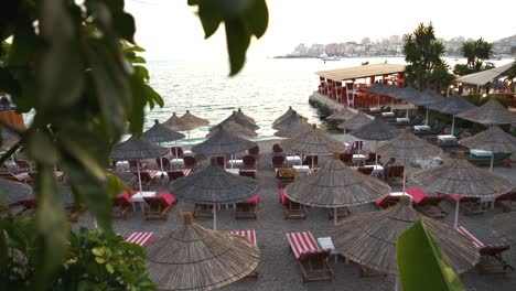 Blick-Auf-Strohschirme-Und-Sonnenliegen-Am-Strand-Am-Meer-In-Saranda