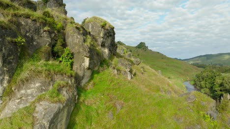 Limestone-rock-formations-on-grass-hill-in-New-Zealand,-rocky-landscape