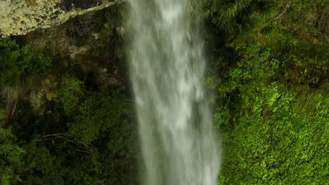 Close-up-of-powerful-water-flow-of-tall-waterfall-in-New-Zealand,-aerial