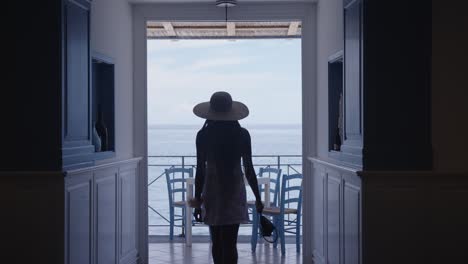 lady-walking-towards-sea-side-restaurant-table-with-blue-ocean-view-in-the-horizon