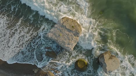 Beautiful-aerial-establishing-view-of-Karosta-concrete-coast-fortification-ruins,-sunny-summer-evening,-golden-hour-light,-stormy-waves-at-Baltic-sea,-ascending-slow-motion-drone-shot