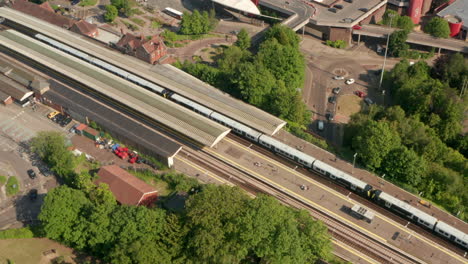 Rising-aerial-shot-of-Basingstoke-train-station-and-town-centre-parking-lot