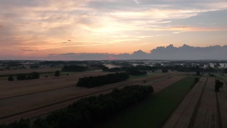 Luftaufnahmen-Des-Sonnenuntergangs-über-Landwirtschaftlichen-Flächen-Mit-Einem-Abgelegenen-Ländlichen-Dorf,-Das-Langsam-Vom-Stromnetz-Lebt