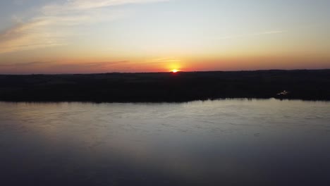 Cinematic-aerial-footage-of-the-sunset-behind-the-river-in-Misiones,-Jardin,-America,-Argentina,-Drone