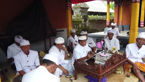 Los-Balineses-Leen-Textos-Hindúes-Sagrados-Tradicionales-En-La-Ceremonia-Del-Templo-En-Bali,-Indonesia,-Vestidos-De-Blanco
