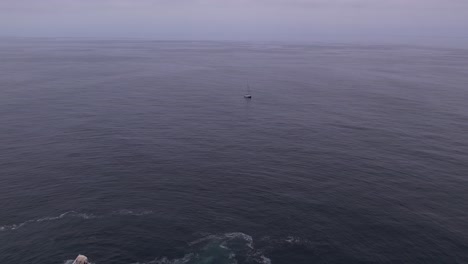 Aerial-shot-pulling-away-from-a-sailboat-near-Big-Sur,-California