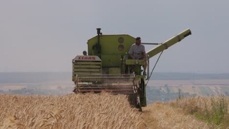 Farmer-Drives-a-Harvesting-Machine-Combiner-and-Harvests-Wheat-and-Cereals