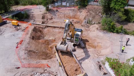 Aerial-view-of-a-construction-site-where-an-excavator-is-loading-dirt-onto-the-back-of-a-loading-truck