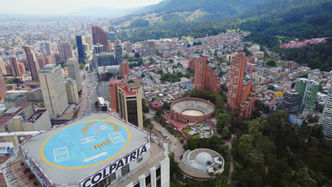 Flying-Past-Building-with-Helipad-to-Reveal-Large-Urban-Metropolitan-City-District-Area-in-Colombia-Latin-America