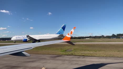 Flugzeuge-Der-GOL-Airlines-Rollen-Und-Passieren-Ein-Flugzeug-Der-United-Airlines-In-Montevideo-Carrasco,-Auch-Bekannt-Als-General-Cesáreo-L