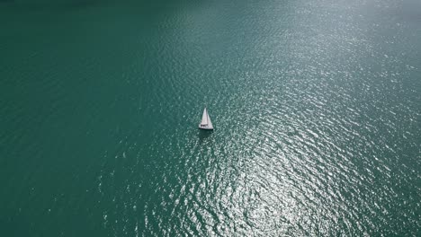 Lonely-sunkissed-yacht-in-Walensee-lake-with-calm-shimmering-water
