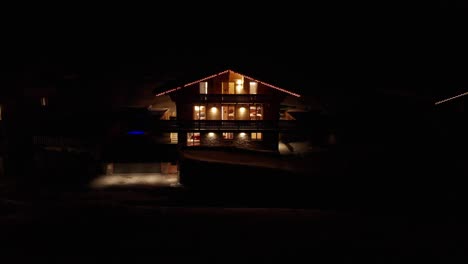 Aerial-of-beautiful-chalet-with-burning-lights-night