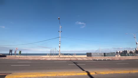 Driving-in-Montevideo-along-the-coastal-road-Rambla-Republica-del-Peru-at-the-corner-of-Playa-Pocitos---Bajada-Buxareo