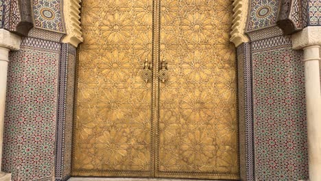 Beautiful-entrance-gate-to-the-Royal-Palace-with-mosaic-and-brass-door-in-Fez,-Morocco